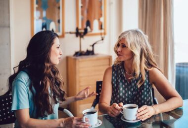 Mujeres de más de 50 años conversan sobre vitaminas y toman un café